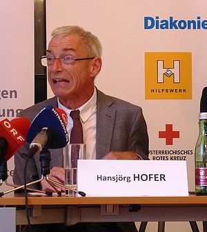 Zu sehen ist Herr Behindertenanwalt Hansjörg Hofer wo er in die Mikrofons spricht.